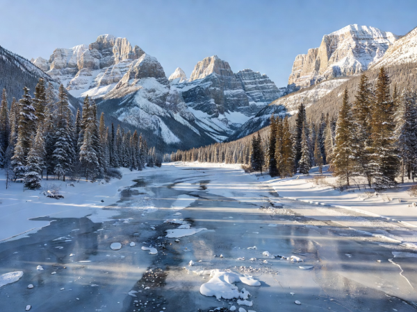 Frozen river valley framed by jagged limestone peaks in Banff