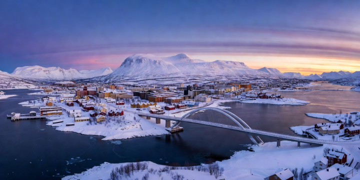 Panoramic view of Tromsø island connected by arched bridge to snow-covered mainland